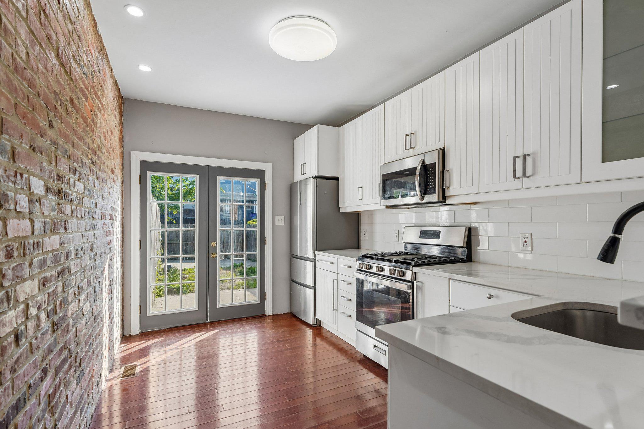 2817 Pelham Avenue Baltimore, MD 21213 - Photo 9 of 25 a kitchen with granite countertop a stove a sink and a microwave