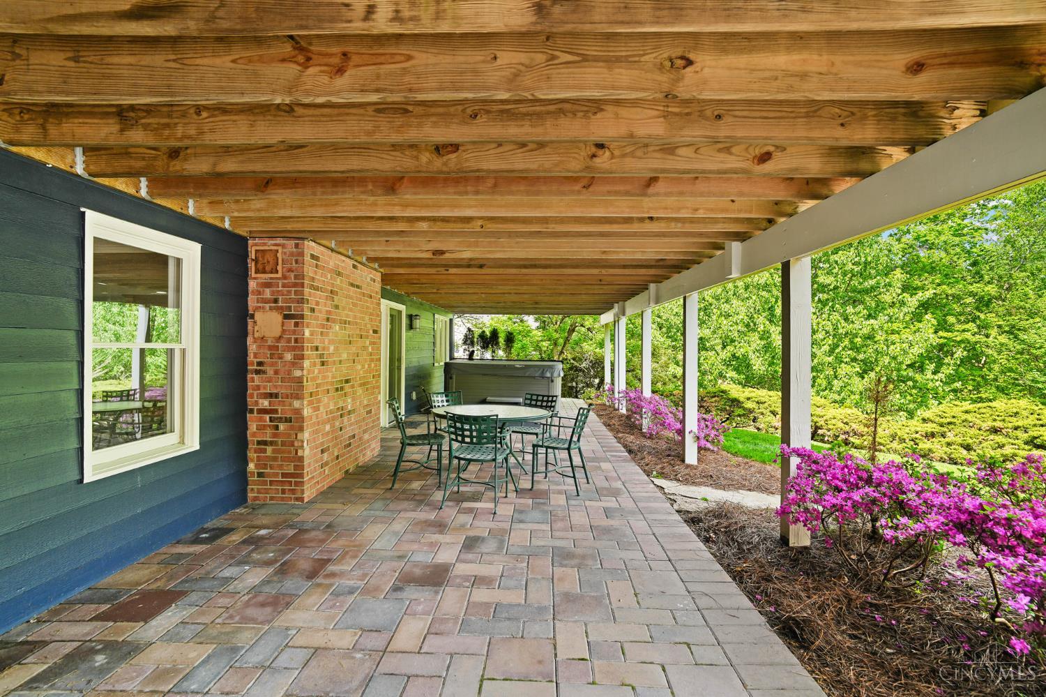 2780 Walsh Road Cincinnati, OH 45208 - Photo 54 of 68 The lower outdoor living areas are thoughtfully designed for both relaxation and entertaining, featuring two distinct patio spaces. A stamped concrete patio offers an attractive, low-maintenance setting ideal for gatherings, while the brick patio tucked beneath the deck creates a more private retreat, complete with a hot tub for year-round enjoyment. Together, these spaces provide a versatile extension of the home, perfect for both lively entertaining and quiet moments outdoors.