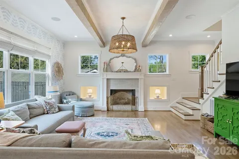a living room with furniture a fireplace and a large window