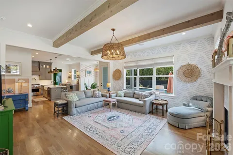 a living room with furniture a chandelier and a large window