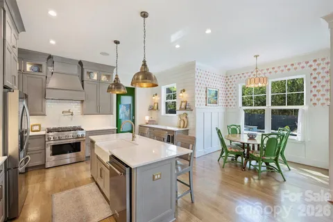 a kitchen with stainless steel appliances granite countertop a stove and a wooden floors