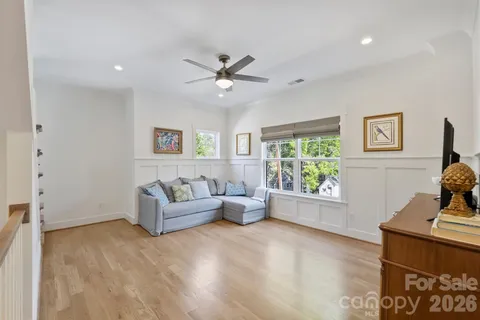 a bedroom with a bed couch and windows