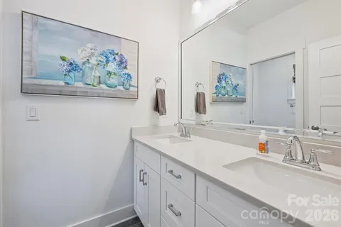 a bathroom with a granite countertop sink a mirror a vanity and a shower