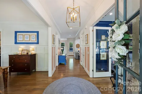 a view of a hallway to a livingroom with furniture