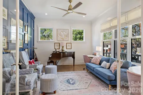 a living room with furniture a flat screen tv and a large window