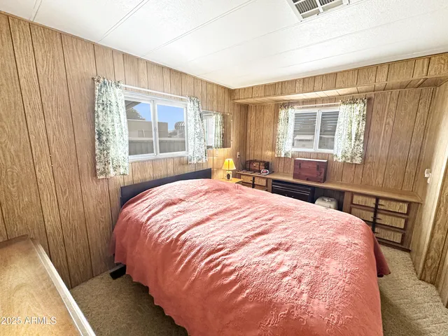a bed sitting in a bedroom next to a window