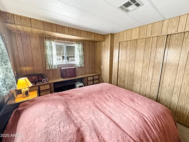 a bedroom with a bed chair and a dresser