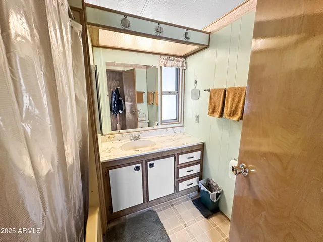 a bathroom with a sink and mirror with bathtub