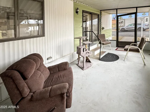 a living room with furniture a flat screen tv and a large window
