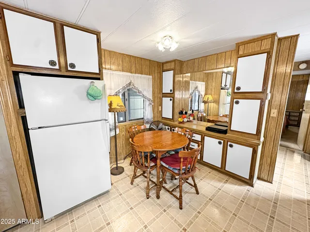 a dining room with furniture a large window and stainless steel appliances
