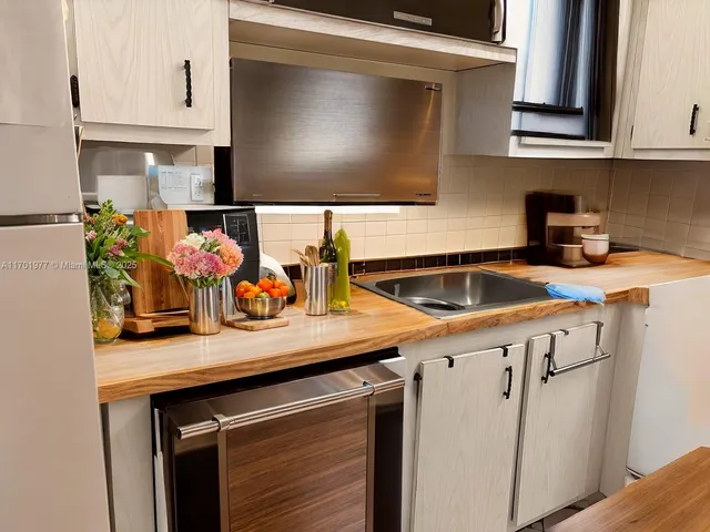 a kitchen with stainless steel appliances a stove a sink and cabinets