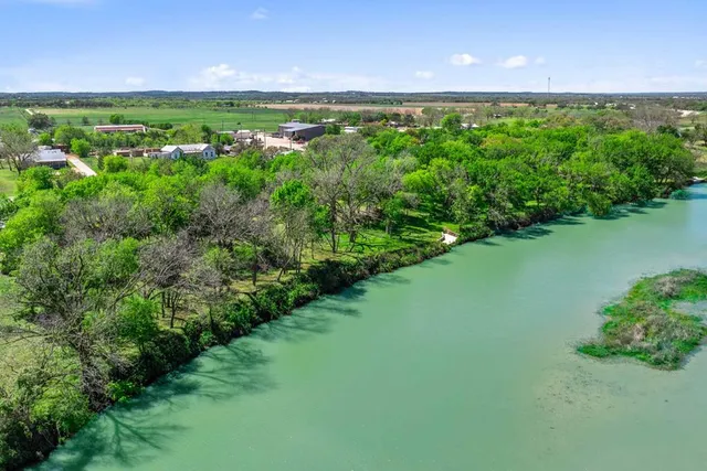 a view of a green yard with lots of green space and a lake view