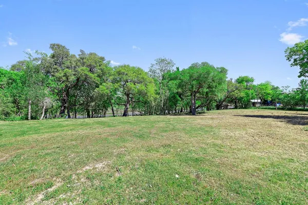a view of a field with trees in the background