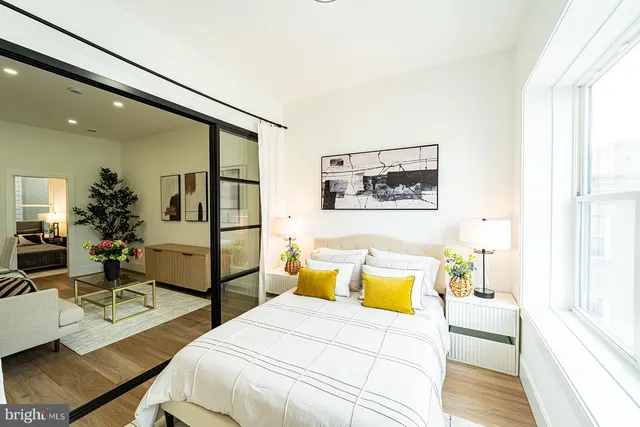 a bedroom with a bed a table and painting on the wall