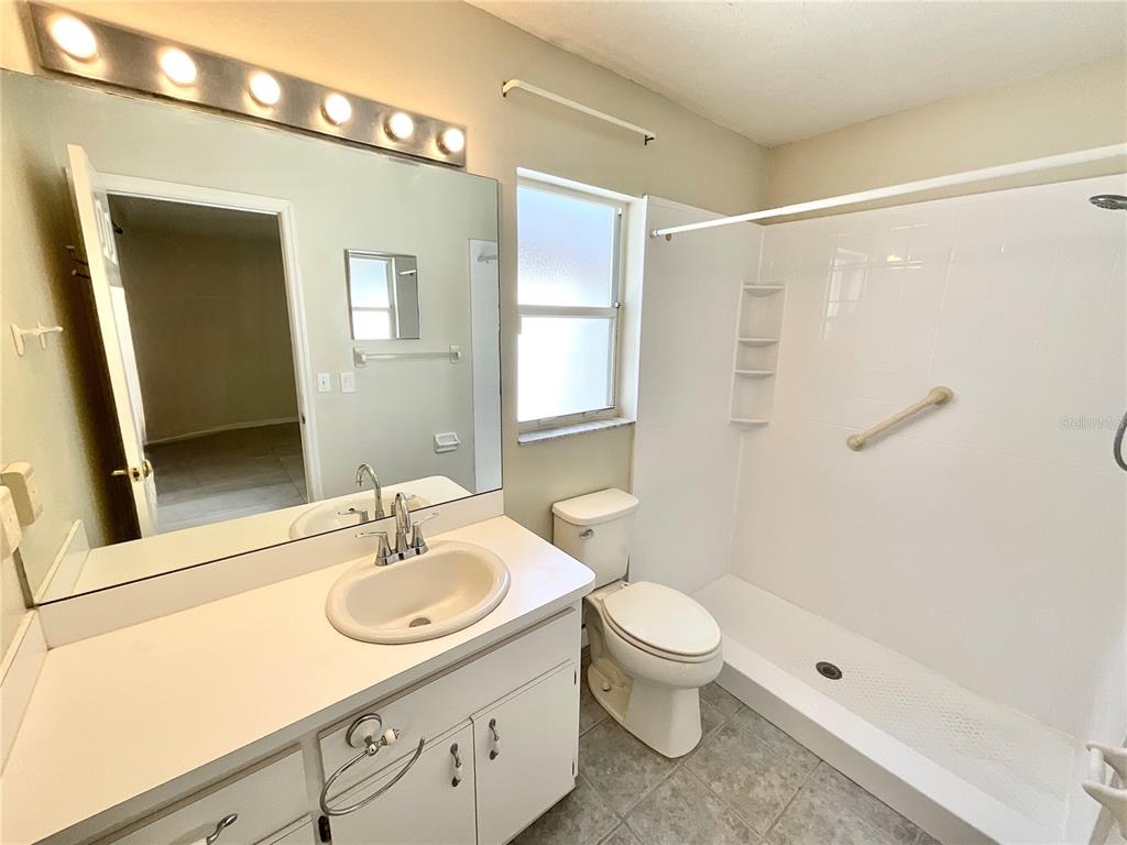 7831 Barclay Road New Port Richey, FL 34654 - Photo 14 of 34 a bathroom with a sink a toilet a mirror and shower