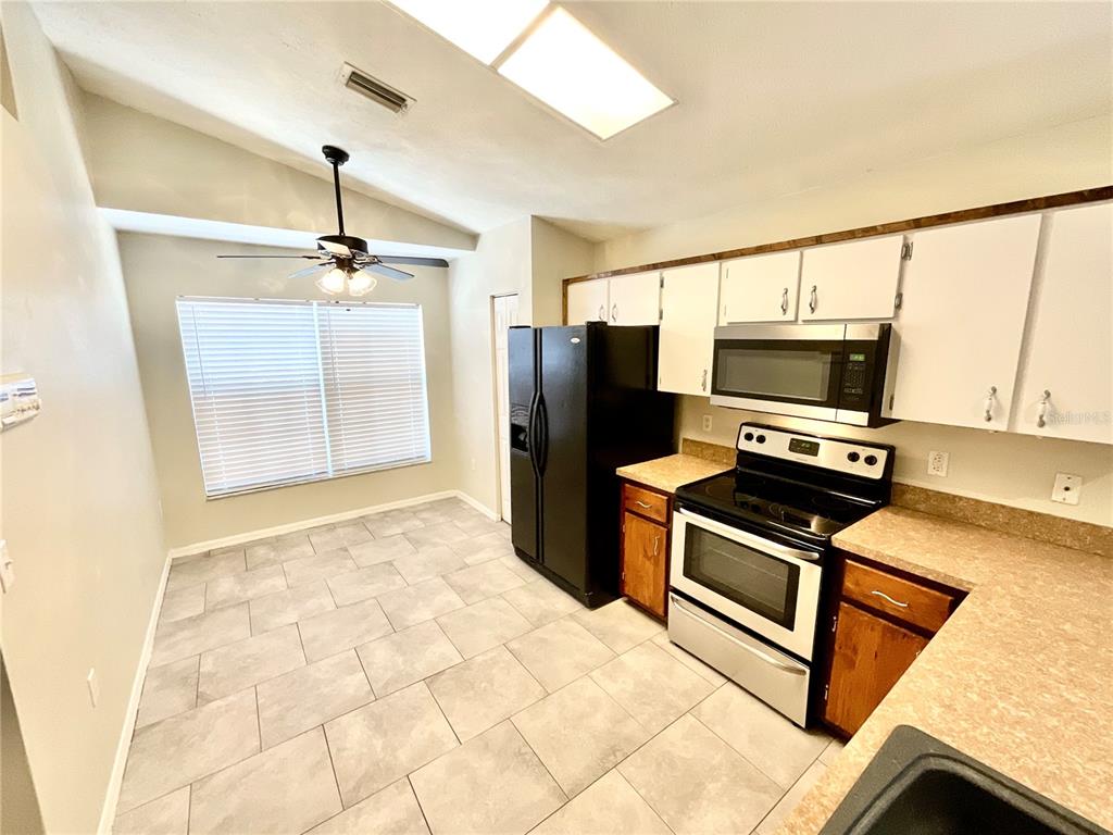 7831 Barclay Road New Port Richey, FL 34654 - Photo 2 of 34 a kitchen with stainless steel appliances a stove a microwave and a refrigerator