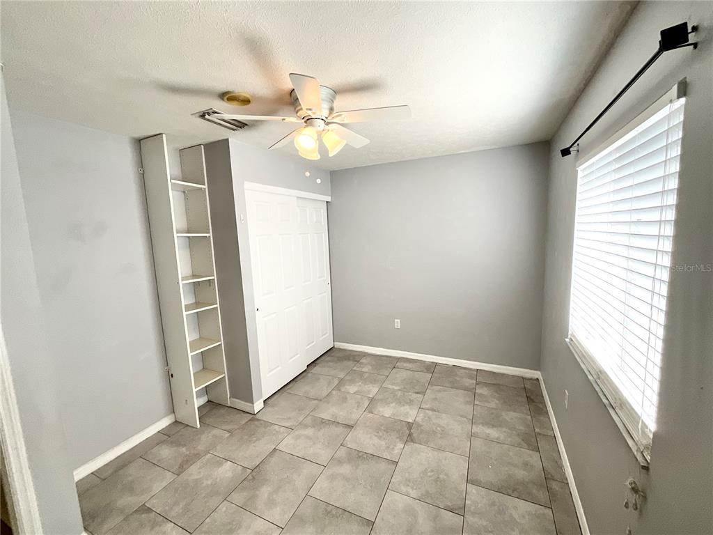 7831 Barclay Road New Port Richey, FL 34654 - Photo 30 of 34 an empty room with windows and fan