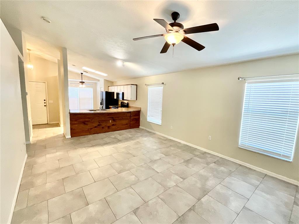 7831 Barclay Road New Port Richey, FL 34654 - Photo 4 of 34 a view of kitchen with refrigerator cabinets and a ceiling fan