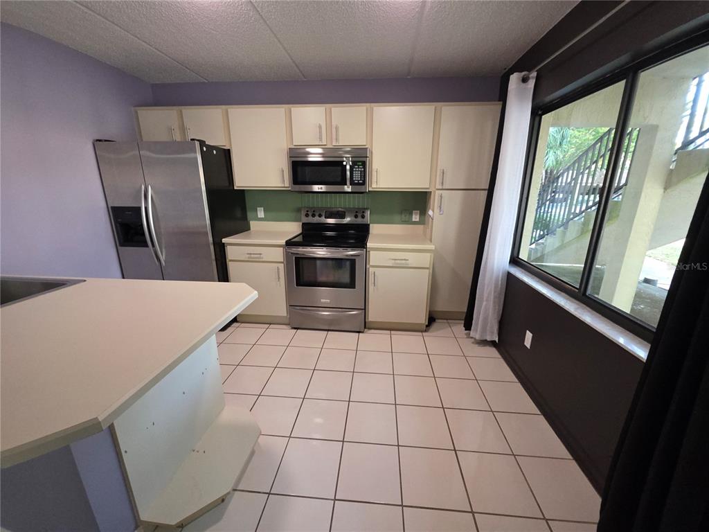 1601 Big Tree Road, Unit 901 Daytona Beach, FL 32119 - Photo 48 of 68 a kitchen with stainless steel appliances a refrigerator a sink a stove top oven a counter space and cabinets