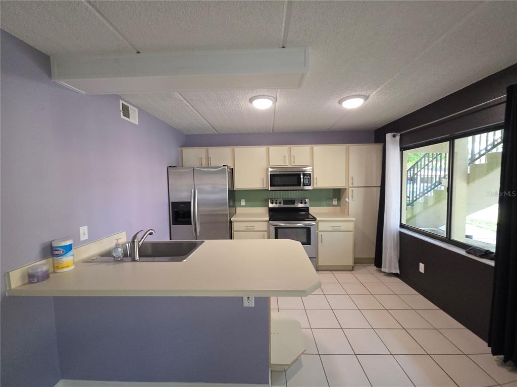 1601 Big Tree Road, Unit 901 Daytona Beach, FL 32119 - Photo 5 of 68 a kitchen with a sink a counter top space stainless steel appliances and cabinets