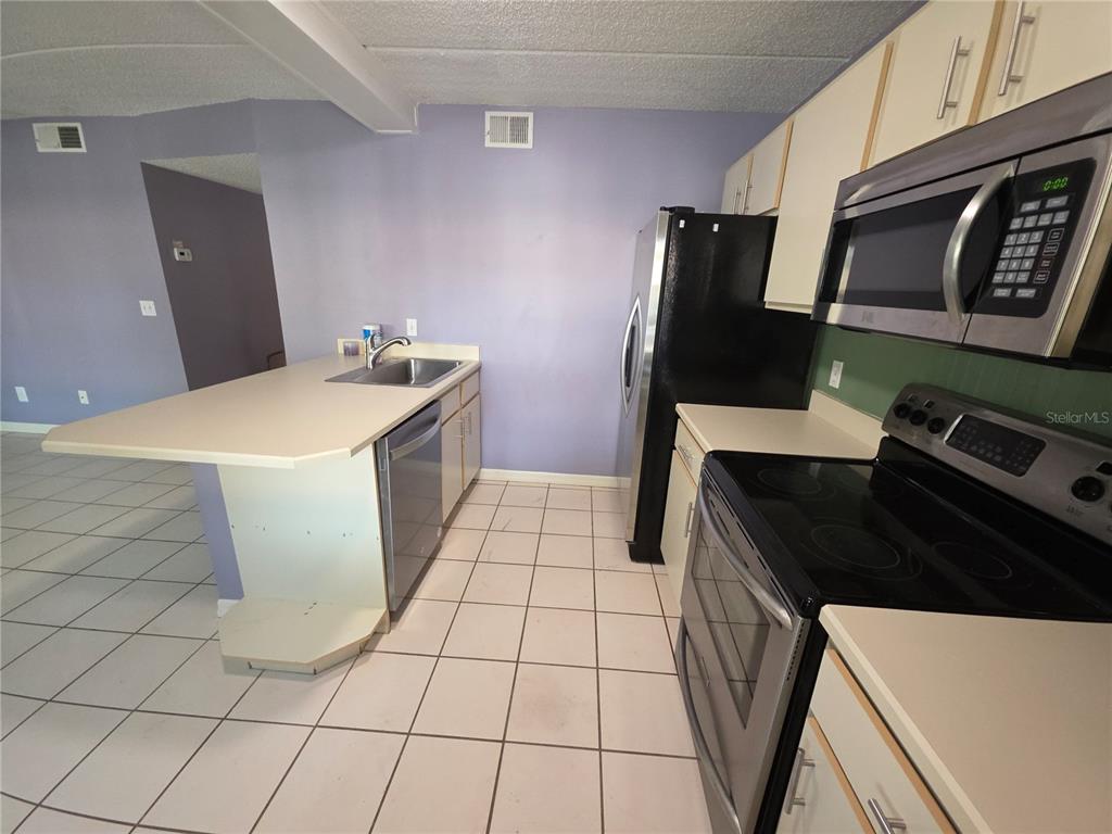1601 Big Tree Road, Unit 901 Daytona Beach, FL 32119 - Photo 9 of 68 a kitchen with a sink and a stove top oven