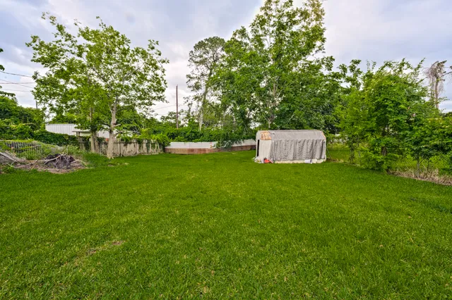a white house that has a big yard and large trees