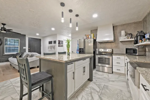 a kitchen with stainless steel appliances kitchen island granite countertop a sink and cabinets