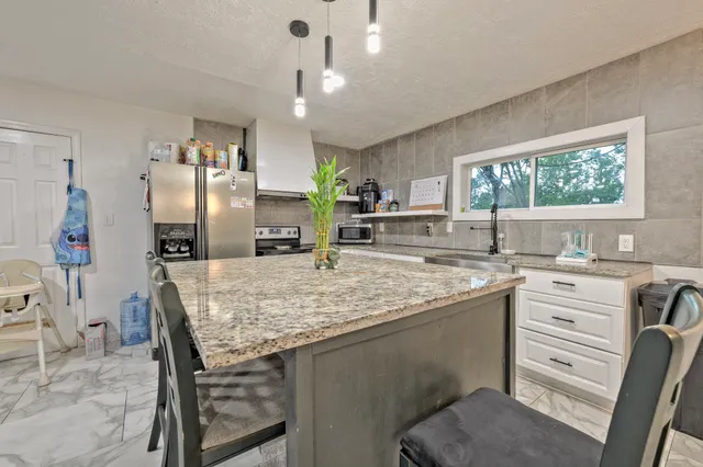 a kitchen with stainless steel appliances granite countertop a sink stove and refrigerator