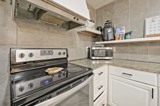 a stove top oven sitting inside of a kitchen