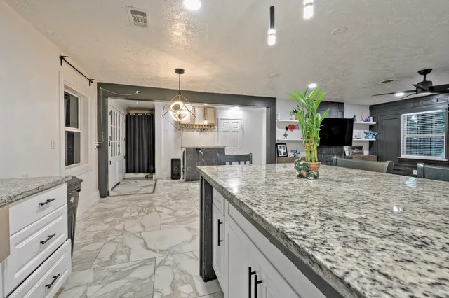 a large kitchen with kitchen island granite countertop a large counter top and sink