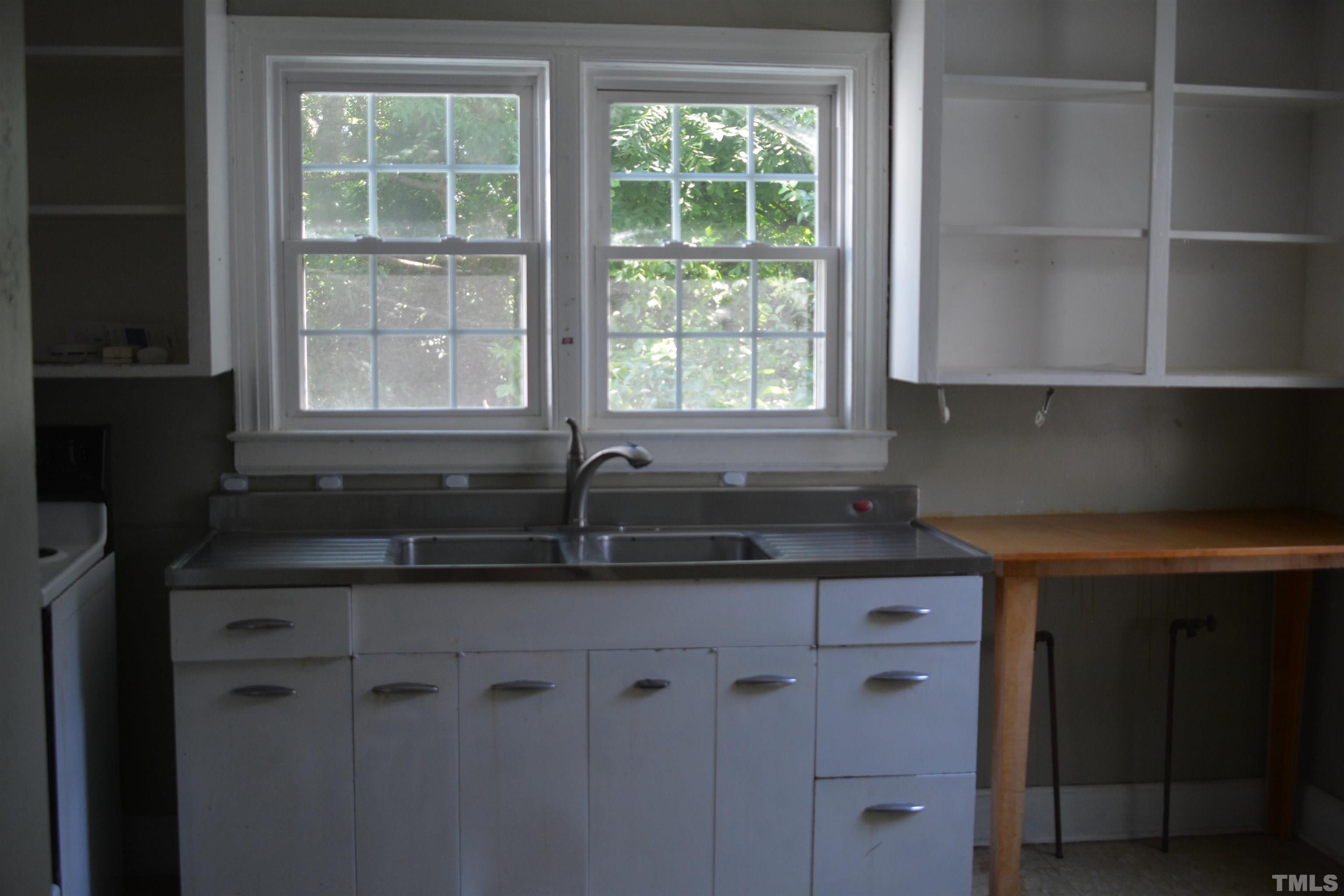 615 Arnette Avenue Durham, NC 27701 - Photo 3 of 12 a kitchen with granite countertop a sink and a window