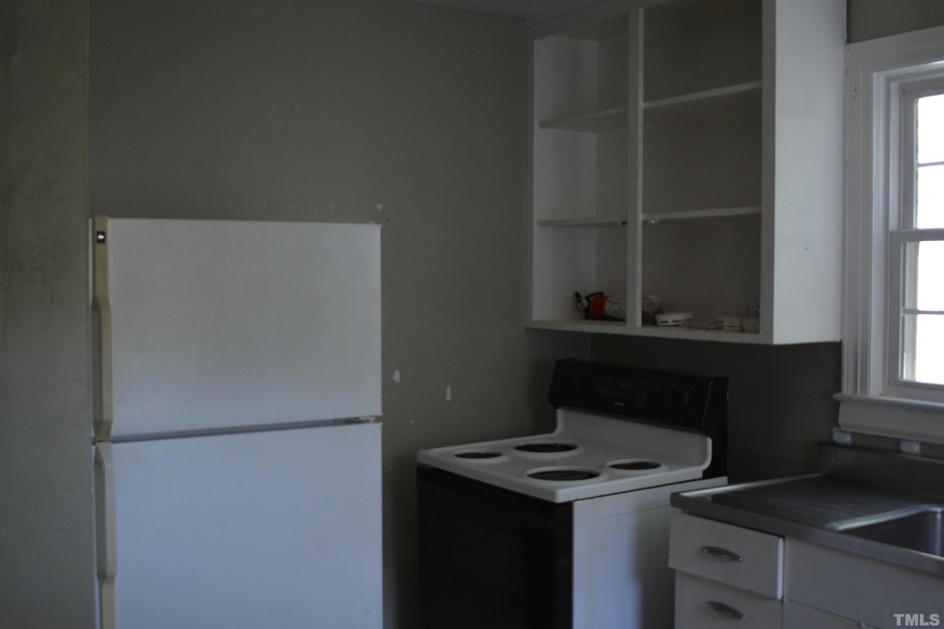 615 Arnette Avenue Durham, NC 27701 - Photo 5 of 12 a kitchen with a refrigerator and a stove top oven
