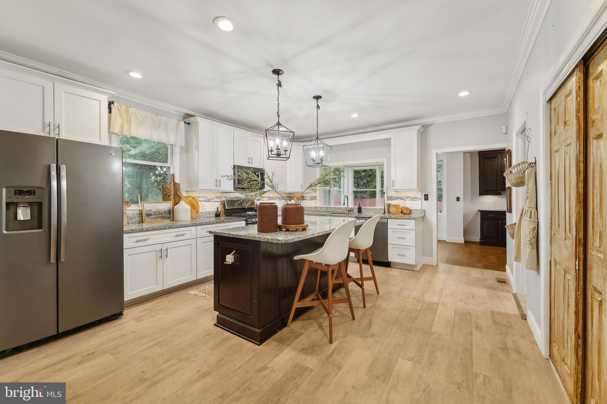 4124 Hamilton Avenue Baltimore, MD 21206 - Photo 13 of 41 a kitchen with stainless steel appliances kitchen island granite countertop a refrigerator a stove a sink a dining table and chairs with wooden floor