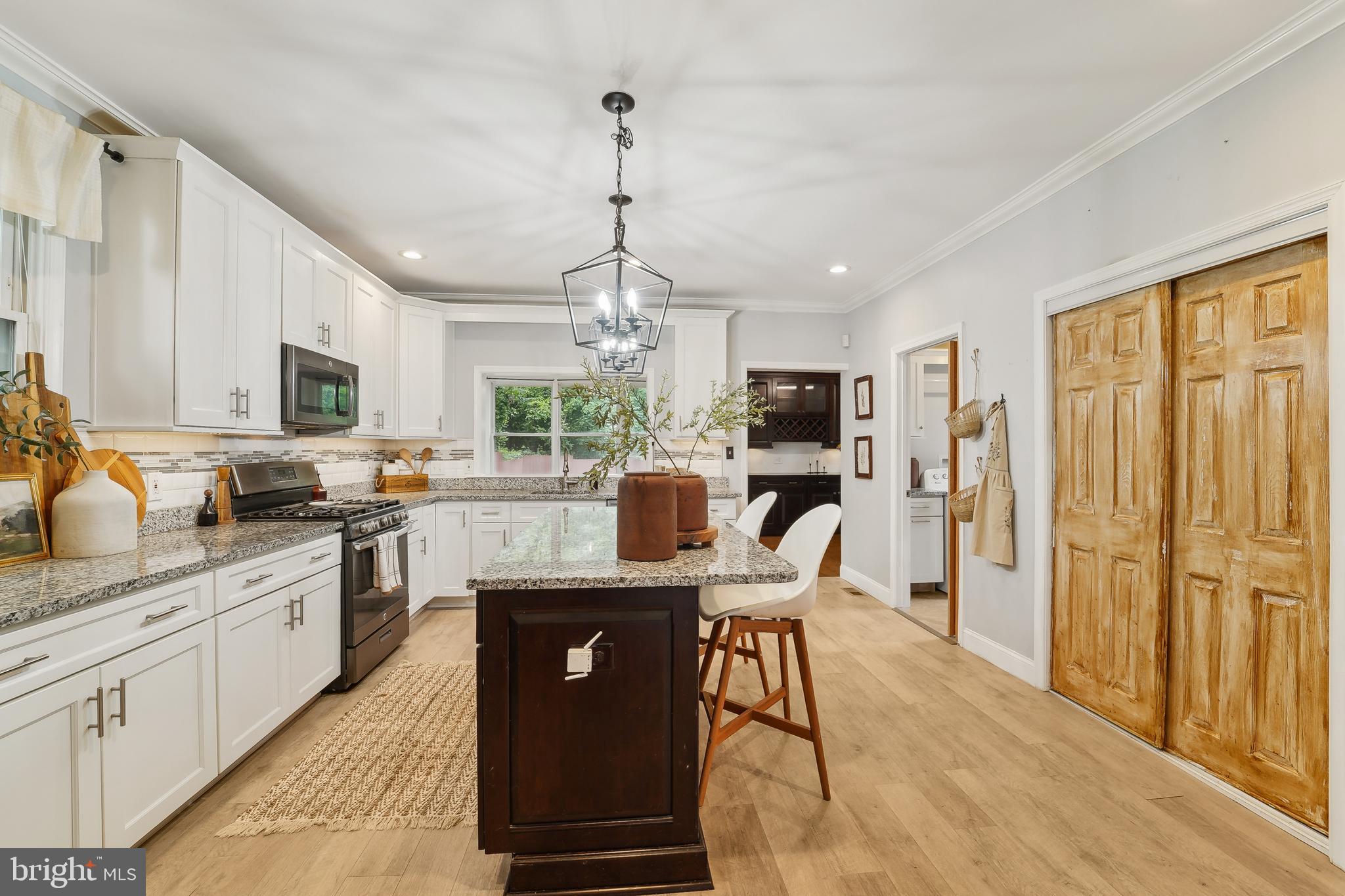 4124 Hamilton Avenue Baltimore, MD 21206 - Photo 14 of 41 a kitchen with stainless steel appliances granite countertop a refrigerator a stove top oven a sink dishwasher a dining table and chairs with wooden floor