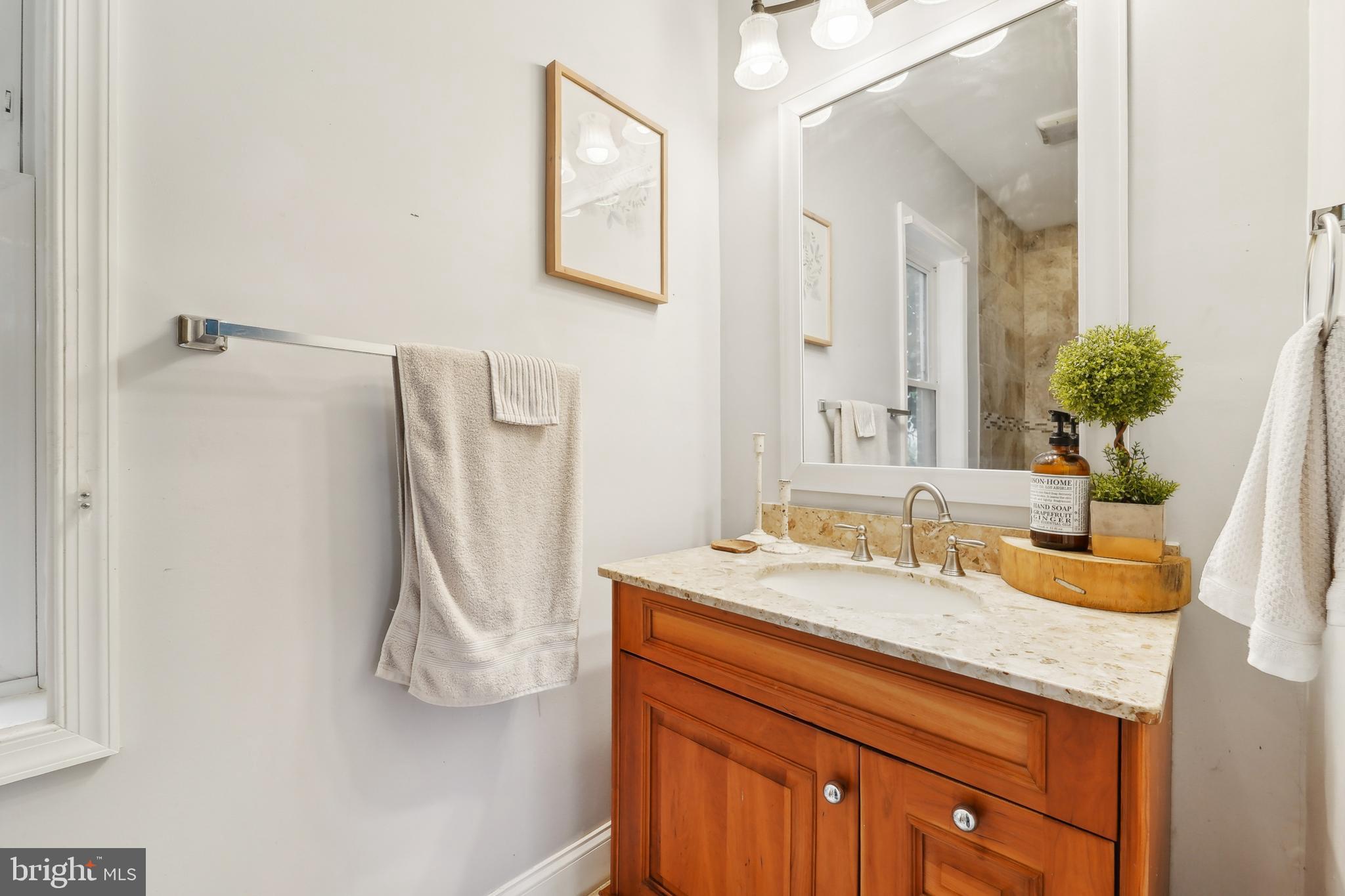 4124 Hamilton Avenue Baltimore, MD 21206 - Photo 36 of 41 a bathroom with a granite countertop sink and a mirror