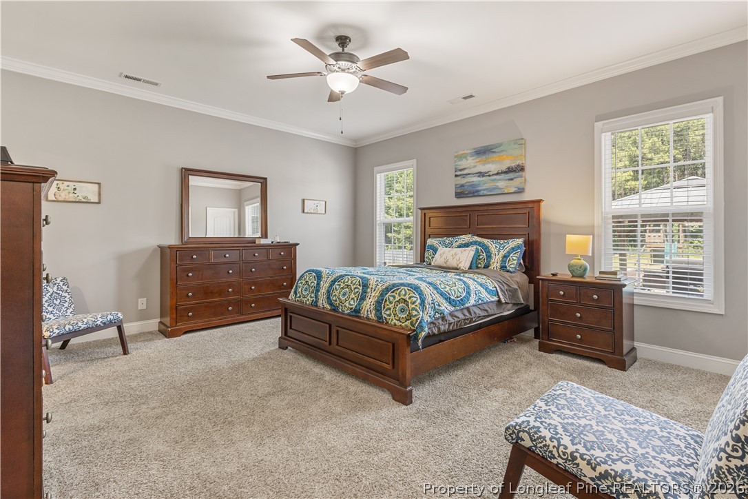 137 Minter School Road Sanford, NC 27332 - Photo 24 of 50 a bedroom with a large bed and a chandelier