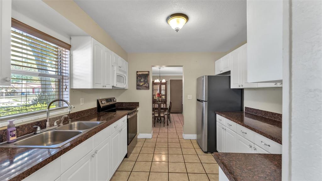 515 Easy Street Bartow, FL 33830 - Photo 6 of 25 a kitchen with granite countertop a refrigerator and a sink