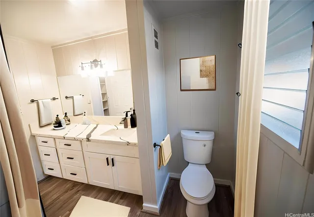 a bathroom with a toilet a sink and mirror