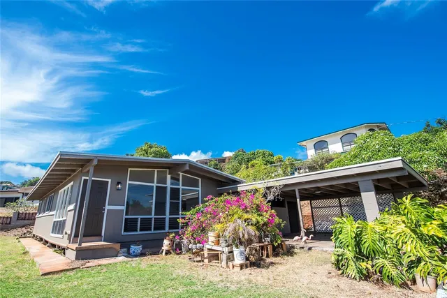 a front view of house with a garden