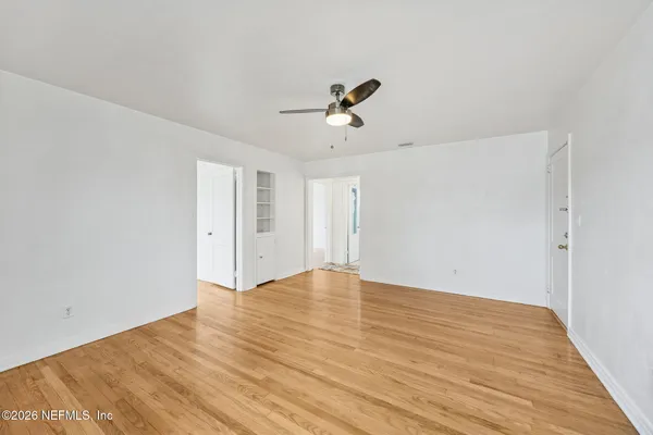 a view of empty room with wooden floor