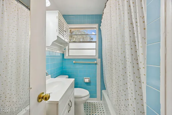 a bathroom with a toilet and a shower curtain