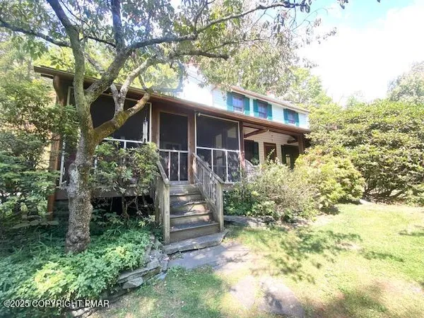 a view of house with a yard and potted plants