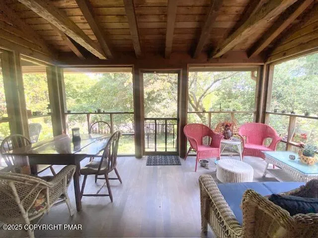 a view of a patio with table and chairs with wooden floor and fence