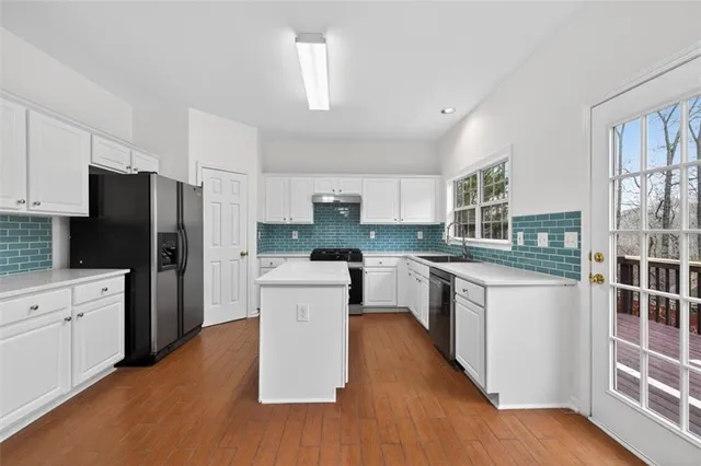 a kitchen with white cabinets and stainless steel appliances
