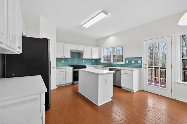 a kitchen with a refrigerator and a stove top oven