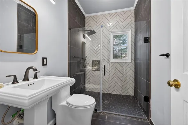 a bathroom with a sink a toilet and shower