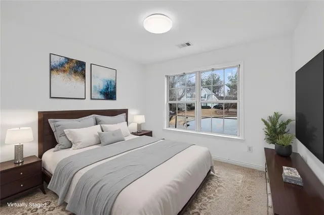 a bedroom with bed and a large window