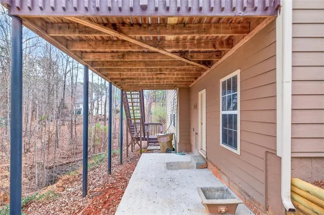 a view of a porch with wooden floor and roof with floor to ceiling window