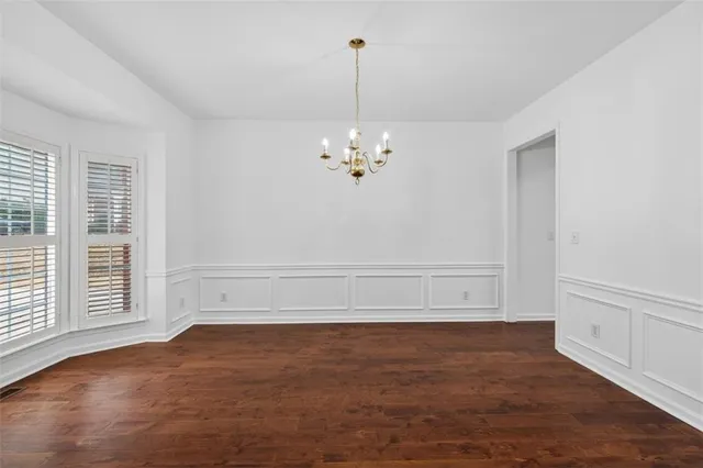 a view of a room with wooden floor and chandelier
