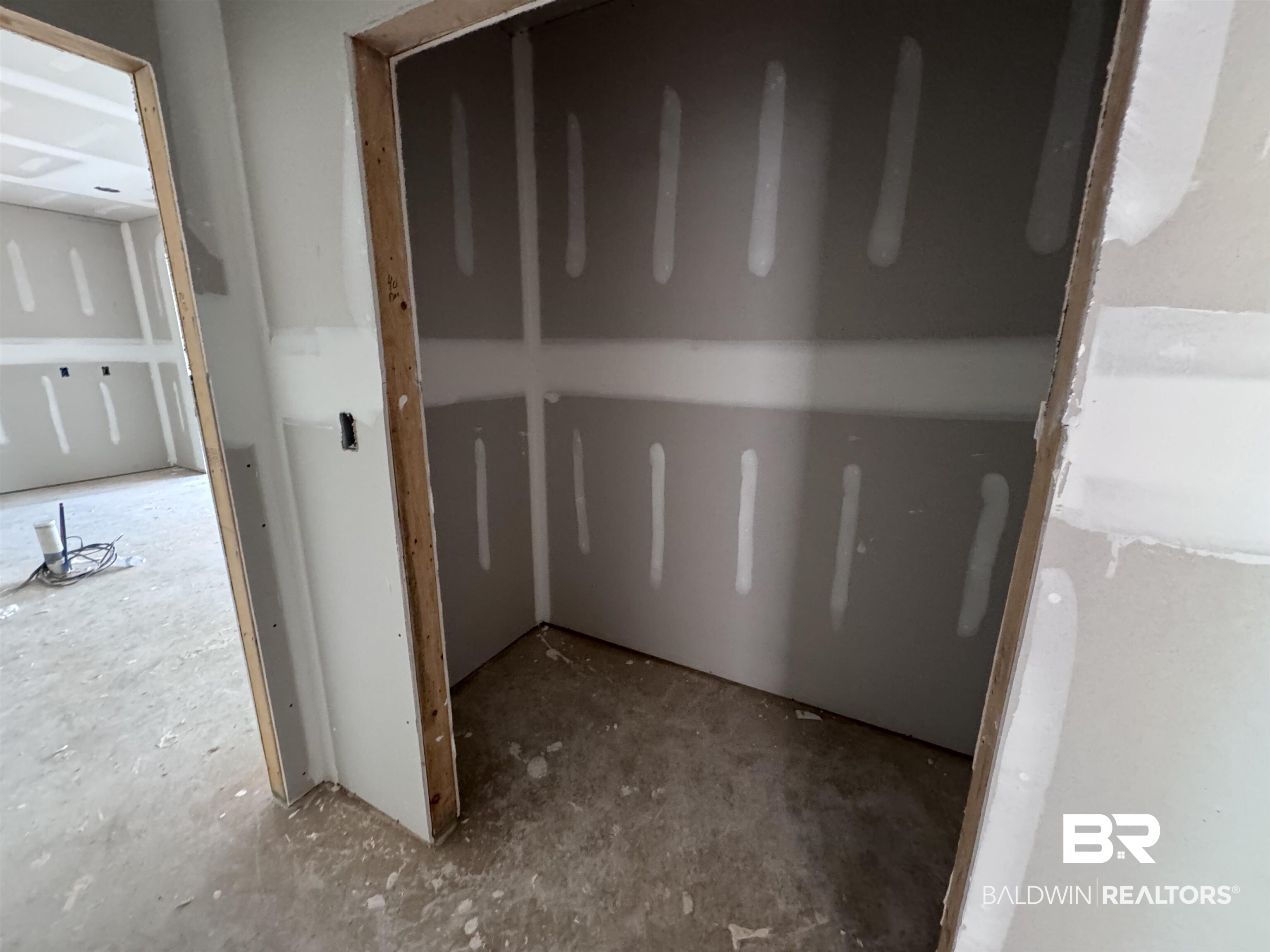 27355 Patch Pl Loop Daphne, AL 36526 - Photo 4 of 17 Unfinished interior with drywall installation, framed entryway, and raw concrete flooring